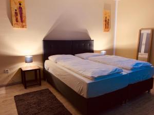 1 dormitorio con 1 cama grande y cabecero de madera en White Pearl Hostel 1 en Núremberg