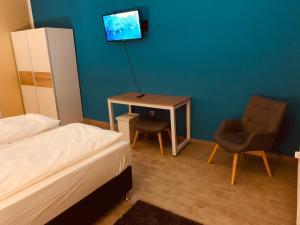 a bedroom with a bed and a table and a chair at White Pearl Hostel 1 in Nuremberg