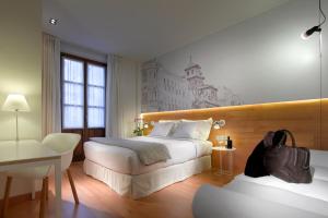 Habitación de hotel con 2 camas y escritorio en Hotel Párraga Siete en Granada