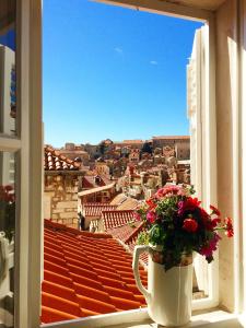 a vase of flowers on a window sill with a view at Studio Doklestic in Dubrovnik