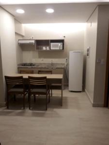 a kitchen with a table and chairs and a refrigerator at Salinas Park Resort in Salinópolis