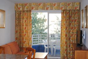 sala de estar con ventana con mesa y sillas en Zahara Rentalmar, en Salou