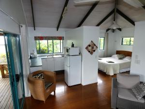 a kitchen and living room with a bed and a refrigerator at Aroa Kainga Bungalows and Apartment in Rarotonga