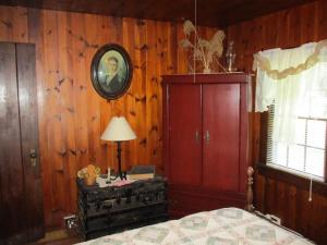 普林斯顿Cabin retreat just off I-77, wonderful experience for 2!的一间带木墙、一张床和一盏灯的卧室