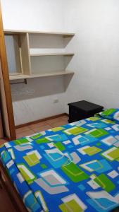 1 dormitorio con 1 cama con edredón azul y verde en Puerto Esperanza - Cabaplan, en Tonsupa