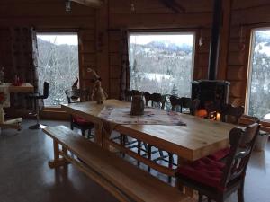 a large wooden table in a room with a fireplace at B&B Le Chalet Bois de Coeur in Saint Come