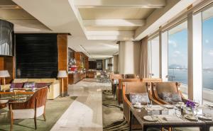 a restaurant with tables and chairs with a view of the ocean at Four Seasons Hotel Hong Kong in Hong Kong