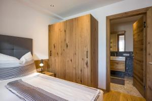 1 dormitorio con 1 cama con pared de madera en Living 5 Walchsee en Walchsee