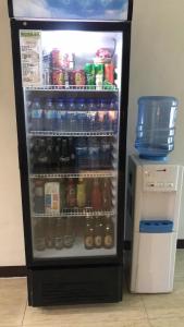 a refrigerator filled with lots of soda and drinks at Meaco Royal Hotel - Malabon in Manila