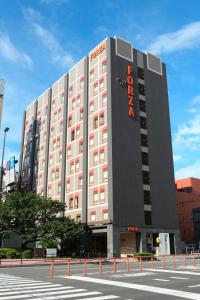 un grand bâtiment avec un panneau sur son côté dans l'établissement Hotel Forza Oita, à Ōita