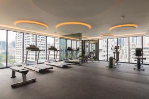a gym with treadmills and machines in a building at Sukhumvit Asok Modern Suite in Bangkok