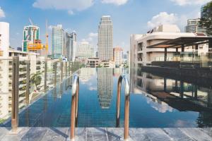 a swimming pool with a city skyline in the background at Sukhumvit Asok Modern Suite in Bangkok