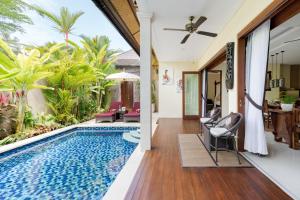 a villa with a swimming pool and a living room at Kubu Gajah Villas in Sanur