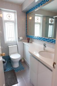 a bathroom with a toilet and a sink and a mirror at Lantau Lodge in Hong Kong