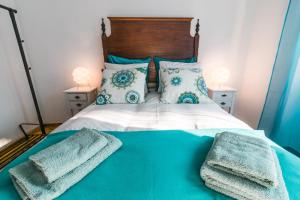 a bedroom with a bed with two towels on it at Lisboa Manaia Home in Lisbon