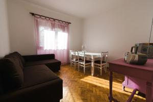 ein Wohnzimmer mit einem Sofa und einem Tisch in der Unterkunft Lisboa Manaia Home in Lissabon