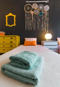 a bedroom with a bed with green towels on it at Lisboa Manaia Home in Lisbon +5 photos