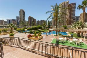 un balcone dell'appartamento con piscina, tavoli e sedie di Gemelos 20 - Beninter All Inclusive a Benidorm