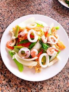 un plato blanco con ensalada con camarones y verduras en Long Beach Hotel, en Tuy Hoa