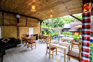 a patio with tables and chairs and a clock at Kubu Kak Dudung Villas in Jimbaran