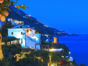 a view of a town at night with the ocean at Hotel Costa Diva in Praiano