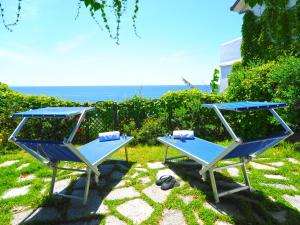 two picnic tables with the ocean in the background at Hotel Costa Diva in Praiano