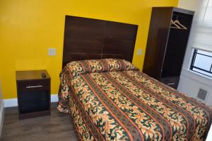 فندق صن رايز في سان فرانسيسكو: غرفة نوم بسرير وجدار اصفر
