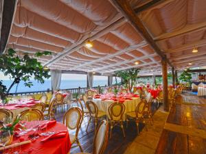 un ristorante con tavoli e sedie con vista sull'oceano sullo sfondo di Locanda Costa Diva a Praiano