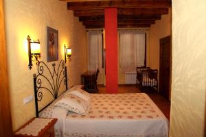 Schlafzimmer mit einem Bett und einer roten Stange in der Unterkunft Casa Rural Arroyo Rechita in La Iruela + 20 Fotos