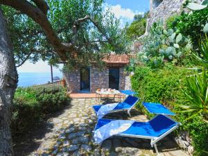 a group of blue chairs and a table in front of a house at Hotel Costa Diva in Praiano
