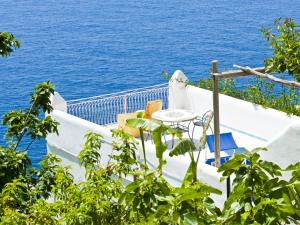 a table and chairs on a balcony overlooking the ocean at Hotel Costa Diva in Praiano