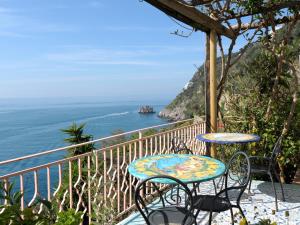 a table and chairs on a balcony overlooking the ocean at Hotel Costa Diva in Praiano
