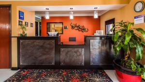 a waiting room with orange walls and a counter at Best Western Kenosha Inn in Broken Arrow