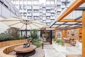 a patio with a table and an umbrella at Chengdu Byway Trip Kuanzhai Alley Branch in Chengdu