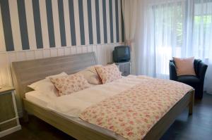 a bedroom with a large bed with pillows and a tv at Heide´s Hotel Pension Bad Bevensen in Bad Bevensen