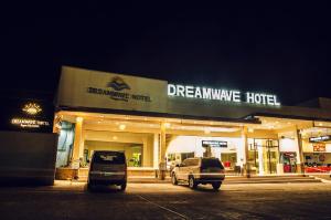 dos coches estacionados frente a un hotel de membranas de ensueño en Dreamwave Hotel Ilagan en Ilagan