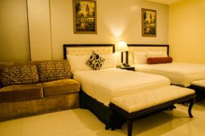 Habitación de hotel con 2 camas y sofá en Dreamwave Hotel Ilagan, en Ilagan