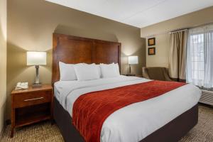 a hotel room with a large bed with a red blanket at Comfort Inn & Suites Hamilton Place in Chattanooga