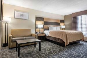 a hotel room with a bed and a chair at Quality Inn & Suites Lafayette I-65 in Lafayette