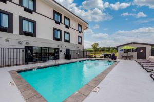 a swimming pool in front of a building at Sleep Inn & Suites Norman near University in Norman