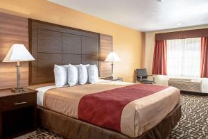 a hotel room with a large bed with white pillows at Executive Inn westley,CA in Westley