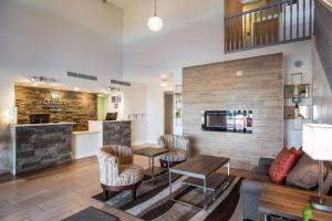 vestíbulo con sofá, mesa y sillas en Quality Inn & Suites West en Pueblo