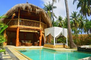 a resort with a swimming pool and a hut at Meno Island Villas in Gili Meno