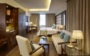 a hotel room with a bed and a couch at Deventure Sarovar Portico Kapashera, New Delhi in New Delhi