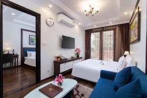 Hanoi Central Hotel & Residences في هانوي: غرفة الفندق بسرير ومرآة