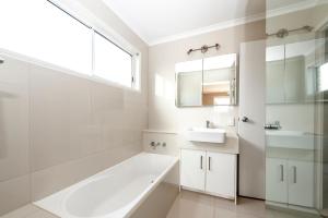 a white bathroom with a tub and a sink at Saltwater Villas - Pet Friendly Accommodation in Mooloolaba +103 photos