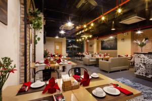 un restaurante con mesas de madera con arcos rojos en Ale Nha Trang Hotel, en Nha Trang