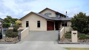 a house with a driveway in front of it at Haven on Glenaven B&B in Motueka