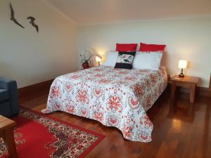 a bedroom with a bed with a red and white blanket at Haven on Glenaven B&B in Motueka