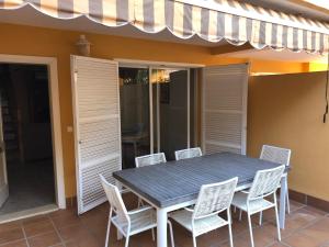 a dining table and chairs on a patio at La casa del perelló in Sueca